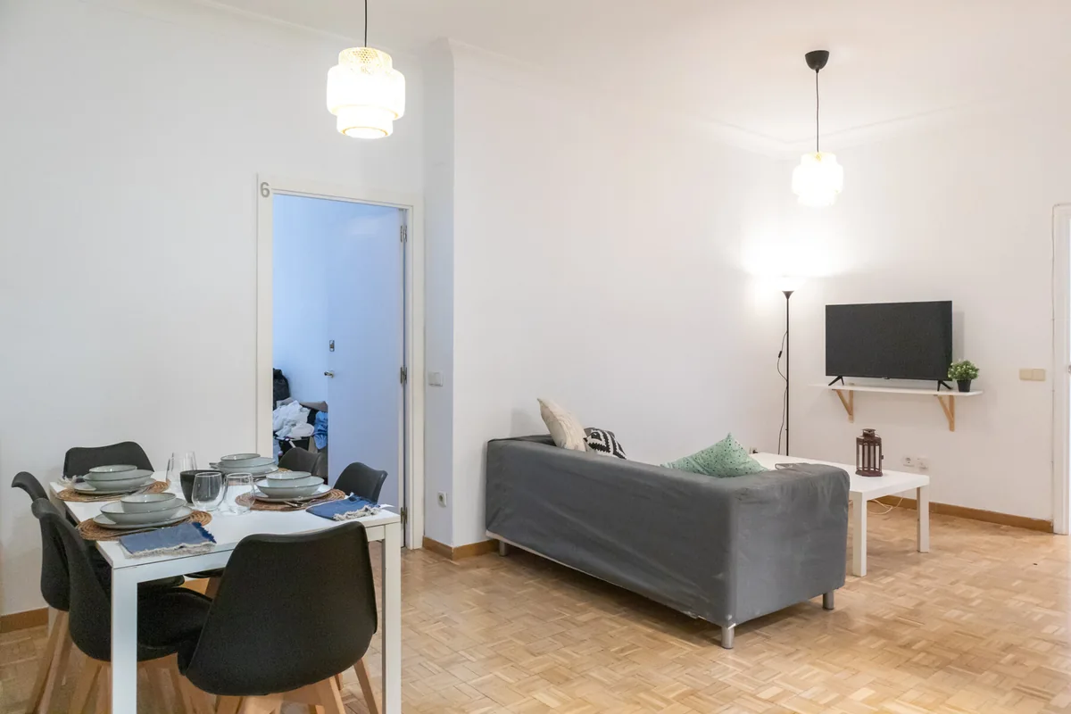 Salón del proyecto San Bernardo con sofá, televisión y mesa de comedor.